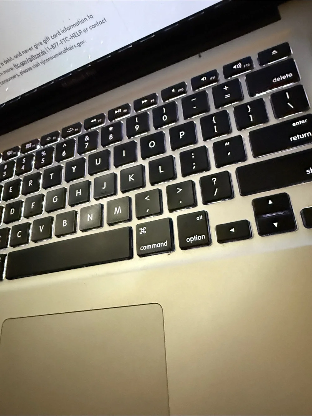 Apple Laptop with Silver Chassis and Black Backlit Keyboard